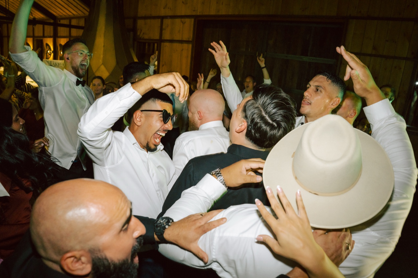Groomsmen singing with arms in the air